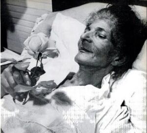 Photograph of Black holding a rose on her deathbed in 1951