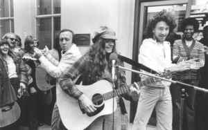 Beth Elliot (in front) performing live on KSAN-FM, with Terry McGovern (in back left) and Fee Waybill (in back right), in front of an audience, 1977, San Francisco, CA. image via: the outwards archive