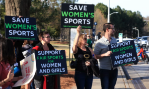 Three years after the bill was introduced, Anti-trans protesters hold up signs before the 2022 NCAA Division I women’s swimming and diving championships at the McAuley Aquatic Center on the campus of the Georgia Institute of Technology. Photograph: Justin Casterline/Getty Images